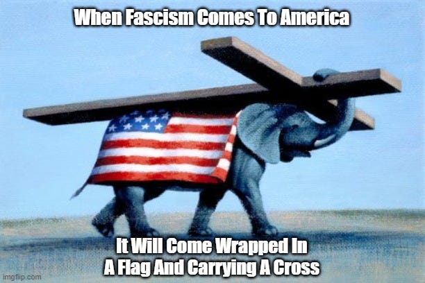 An elephant wrapped in a US flag holds a large cross on its back as it walks across a bleak landscape. Caption: When Fascism comes to America it will come wearing a flag and carrying a cross"