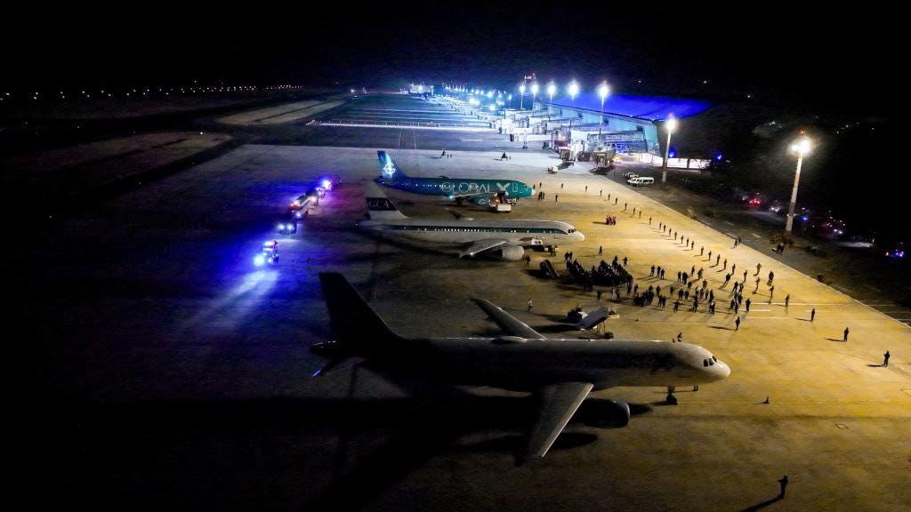 Salvadoran police officers escorting deported Venezuelan gang members from the U.S., at El Salvador International Airport, to be imprisoned in CECOT prison