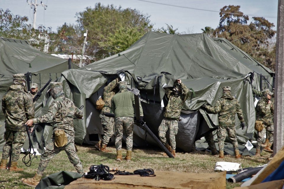 Mexican Navy soldiers erecting a temporary shelter at the US-Mexico border.