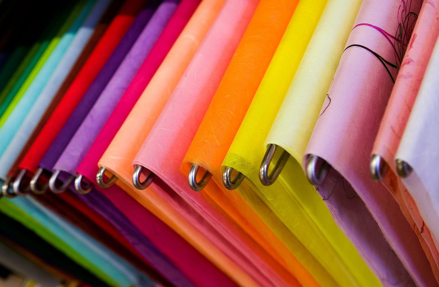 Brightly coloured paper draped over a row of metal rods