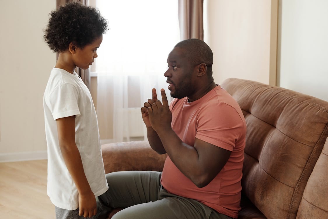 Free Father and son having an important talk at home, focusing on parenting and communication. Stock Photo