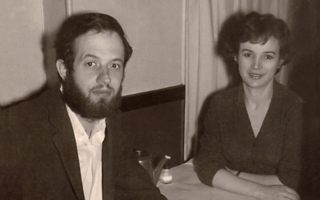sepia photo of a bearded man and smiling woman with short stylish hair sitting at a table