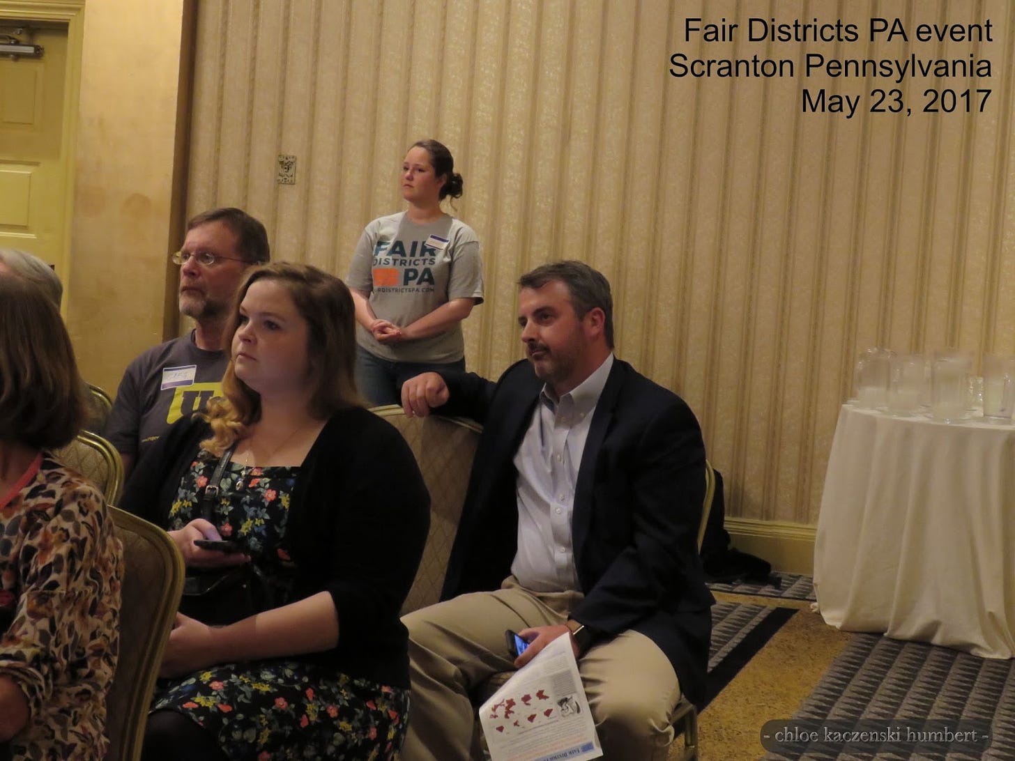 Kyle Donahue sitting in the back holding a pamphlet and cell phone listening to the speakers at a Fair Districts PA event at the Radisson Hotel in Scranton Pennsylvania. May 23, 2017. Photo by Chloe Kaczenski Humbert.