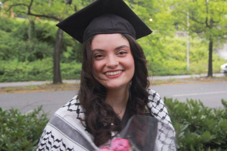 a woman in a graduation hat and keffiyeh smiling