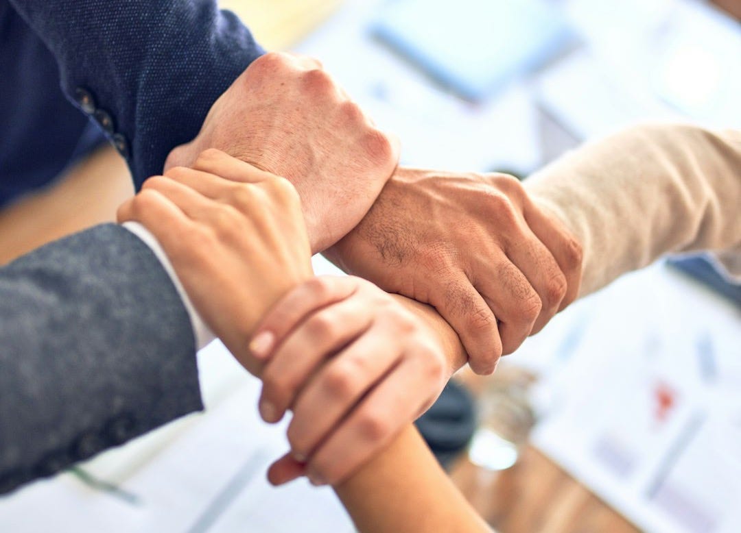 person in black long sleeve shirt holding persons hand