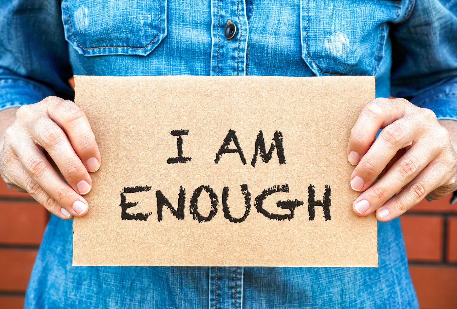 Person holding sign that says I Am Enough.