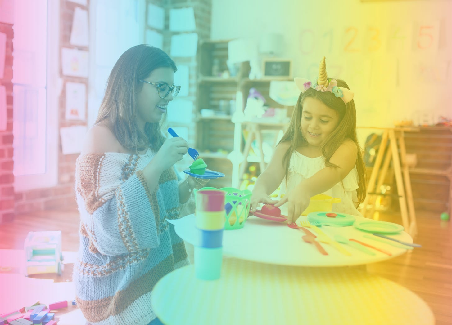 A rainbow-ombre filtered image of a woman kneeling down with a little girl and playing with toys on a tabletop