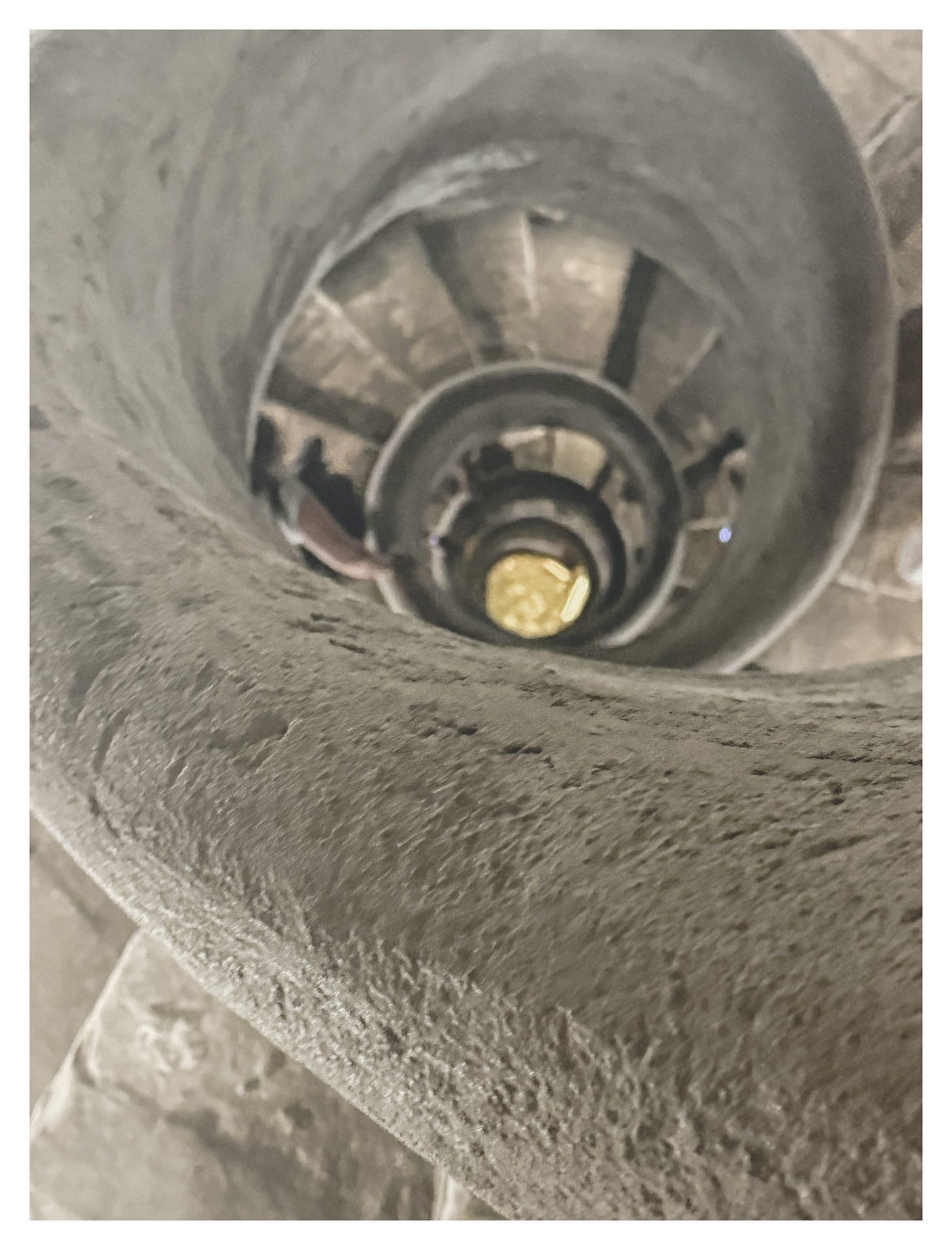 Looking down through the narrow, spiraling stone staircase beneath Villa Medici, with a glimpse of running water below and visitors descending in a blur of motion. Looking down through the narrow, spiraling stone staircase beneath Villa Medici, with a glimpse of running water below and visitors descending in a blur of motion.