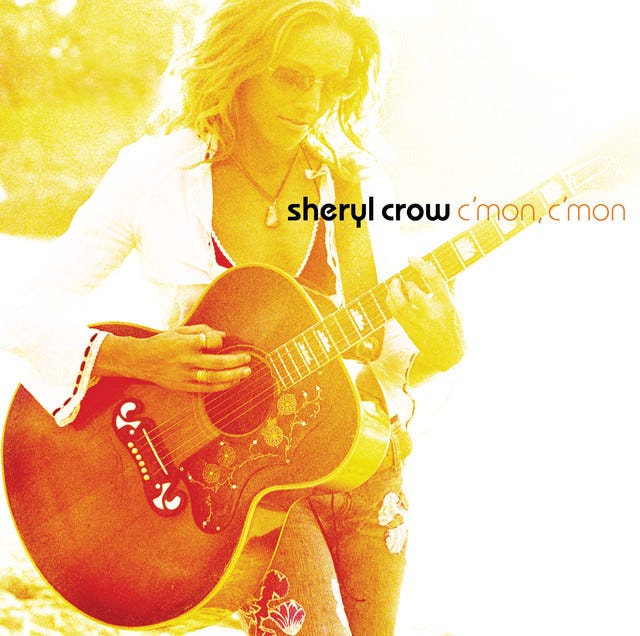 Sheryl Crow holding acoustic guitar on her album cover