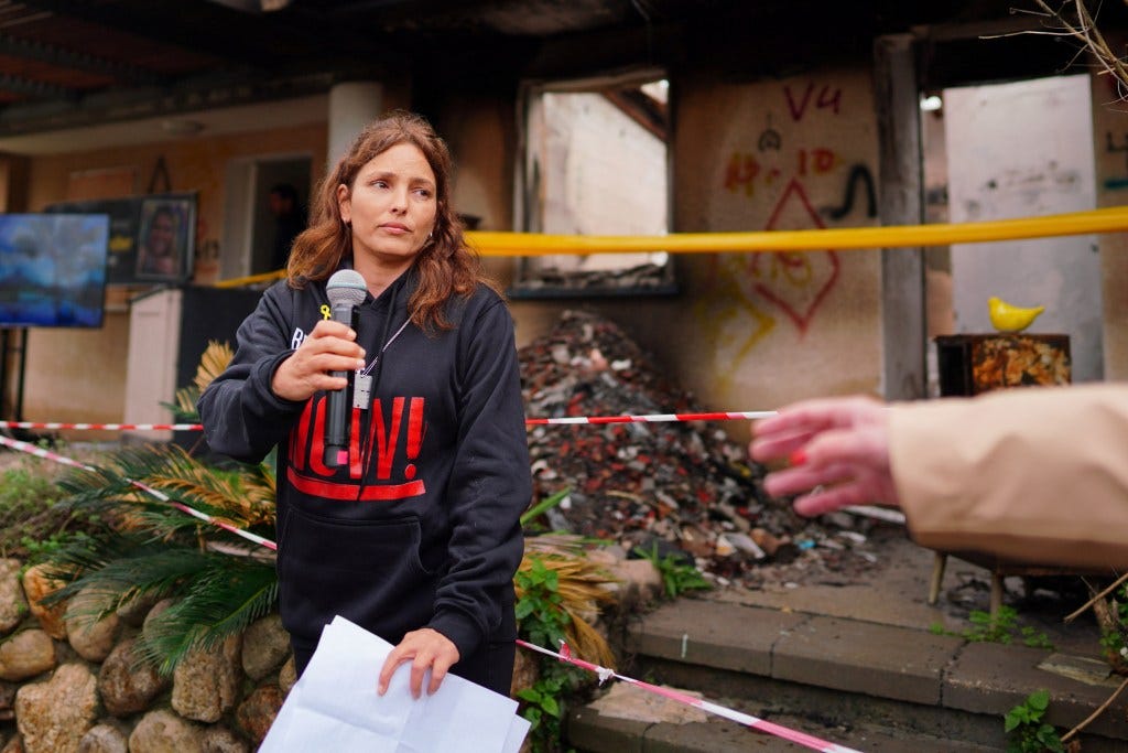 Released hostage Amit Soussana, kidnapped on the deadly October 7 attack by Palestinian Islamist group Hamas, talks to the press in front of her destroyed home
