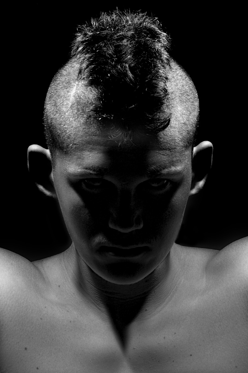 Highlighted Mohawk of a young man in darkness