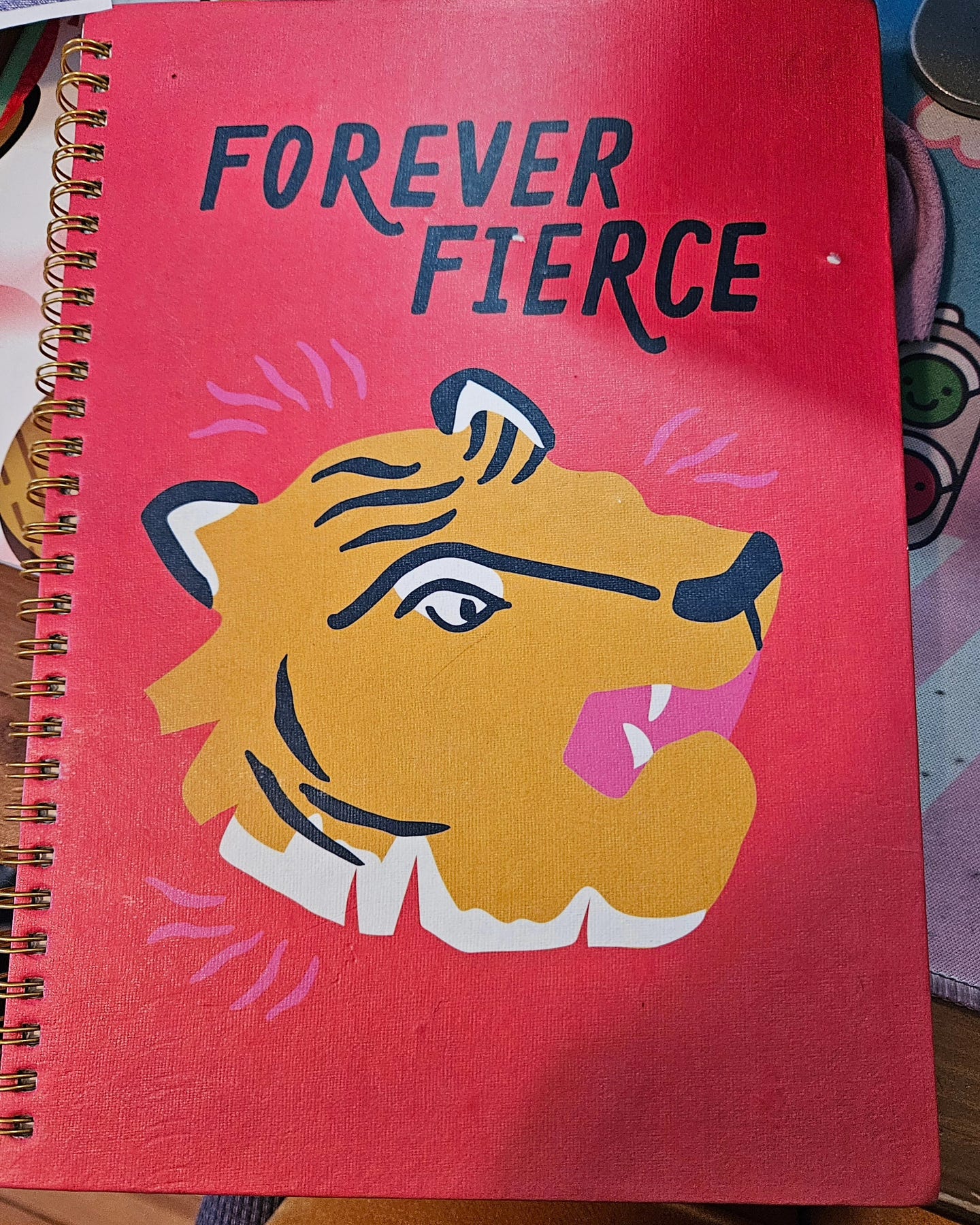 red notebook with badly drawn tiger. forever fierce