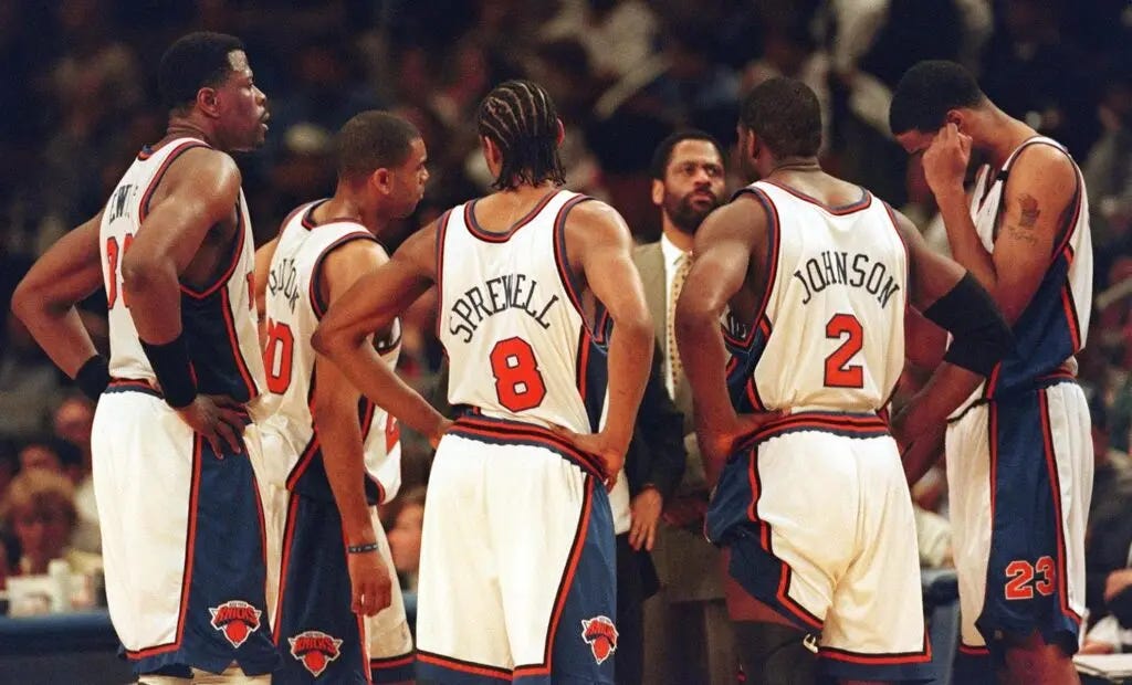 A nearly defeated New York Knicks team meets during a time-out late in the fourth quarter of the fourth game of their Eastern Conference first round play-off series against the Miami Heat at Madison Square Garden in New York 14 May, 1999. From L-R: Patrick Ewing, Allan Houston, Latrell Sprewell (#8), Larry Johnson (#2) and Kurt Thomas (#23). The Heat won, 87-72, to even the series at 2-2. Man in suit is an unidentified coach. AFP PHOTO Stan HONDA (Photo by STAN HONDA / AFP) (Photo by STAN HONDA/AFP via Getty Images)