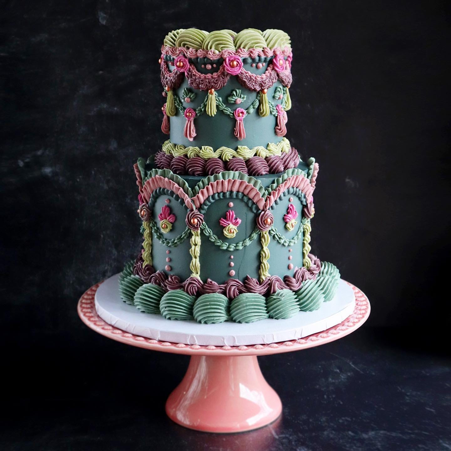two-tier cake with all sorts of piping embellishments