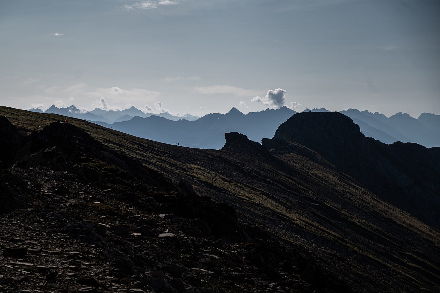 Two runners in the distant running on a mountain ridge