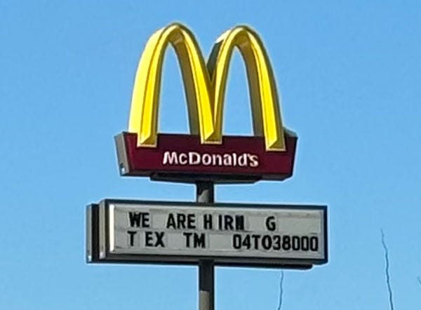 The sign outside of McDonald's with "We Are Hirn___g, T__ex___tm___04to38000" written in bad spacing that's hard to understand