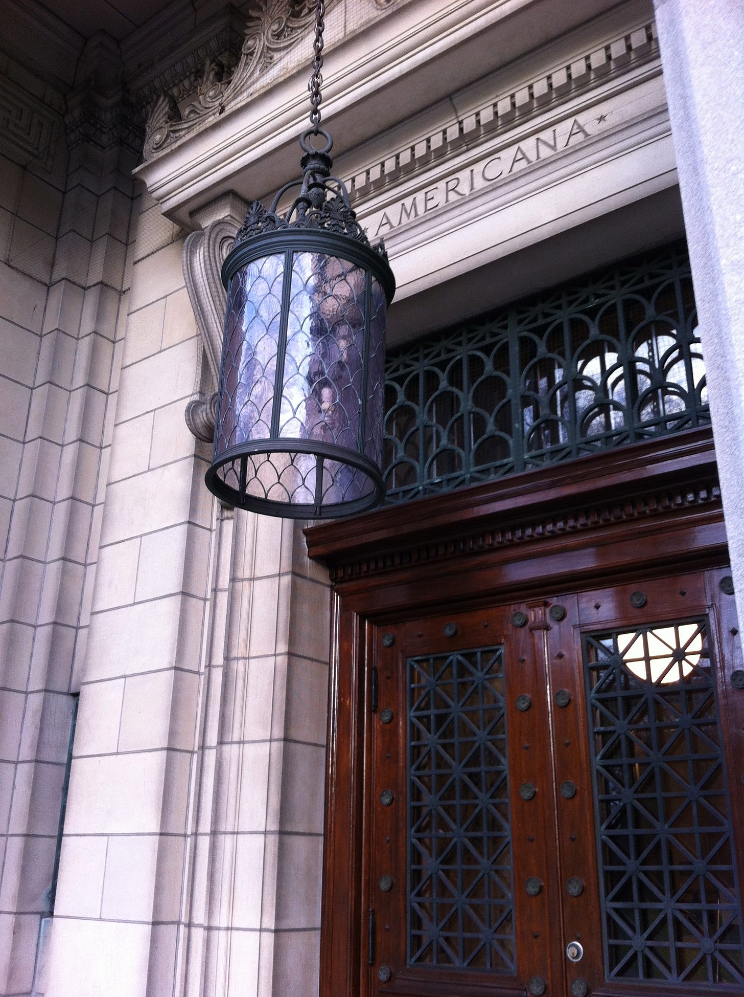 Doorway with an ornate lampshade. "Americana" on the lintel.