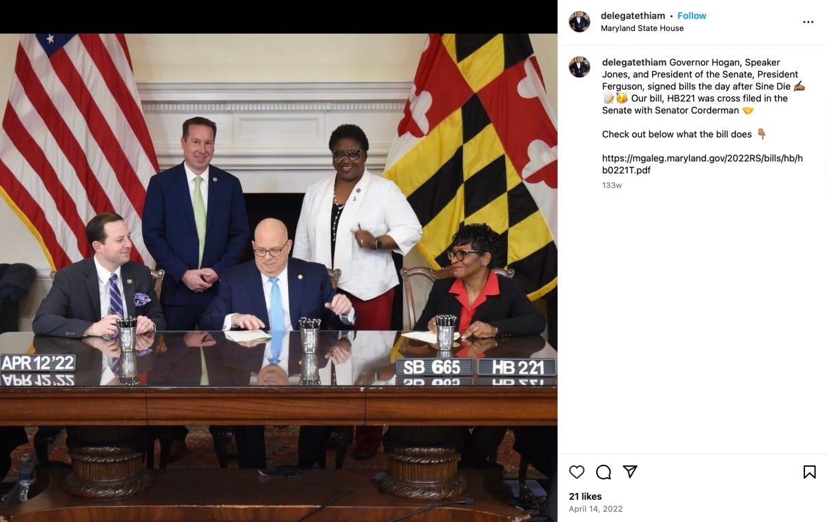 Thiam standing behind Larry Hogan as he signed her legislation 