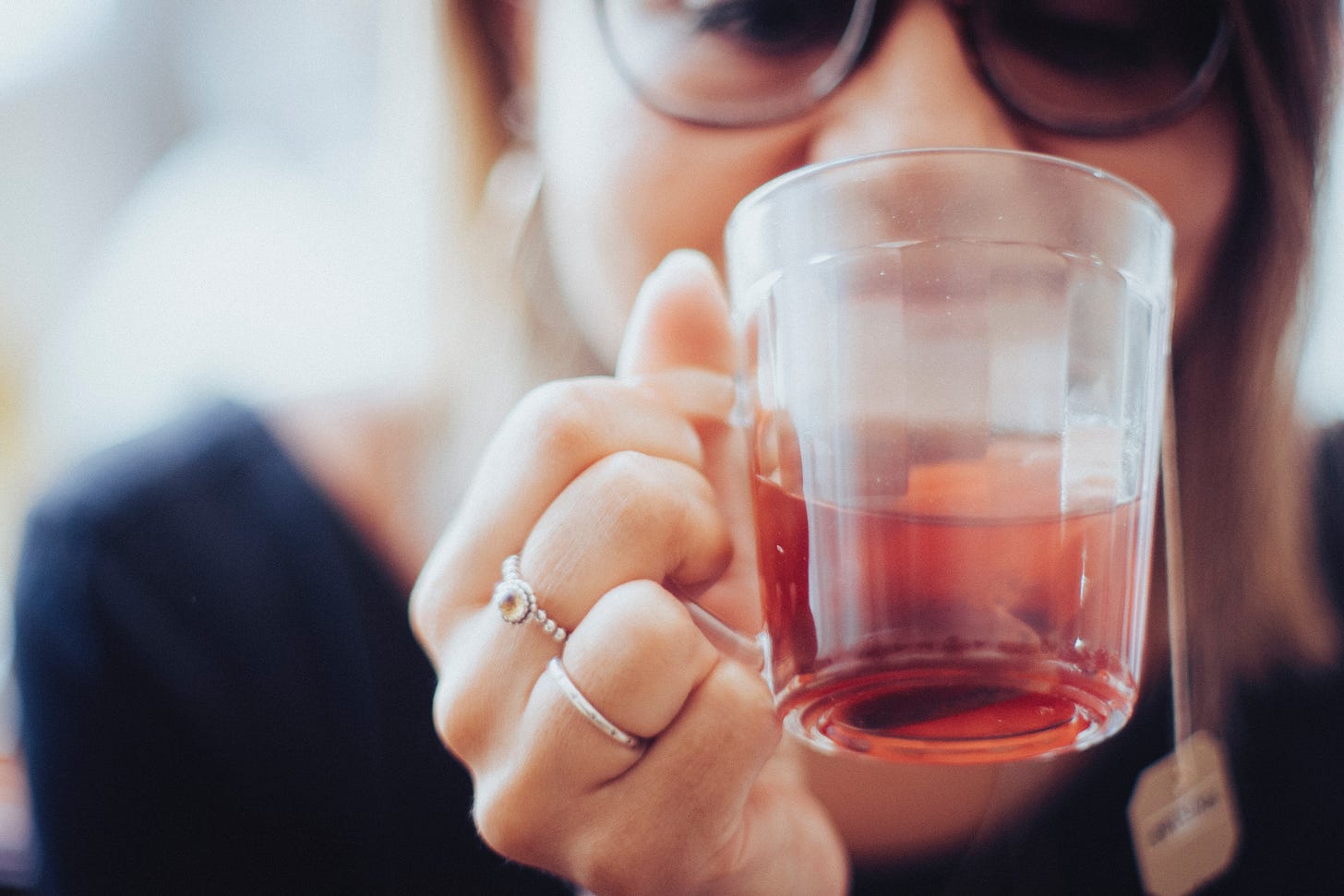 woman wearing glasses drinking tea