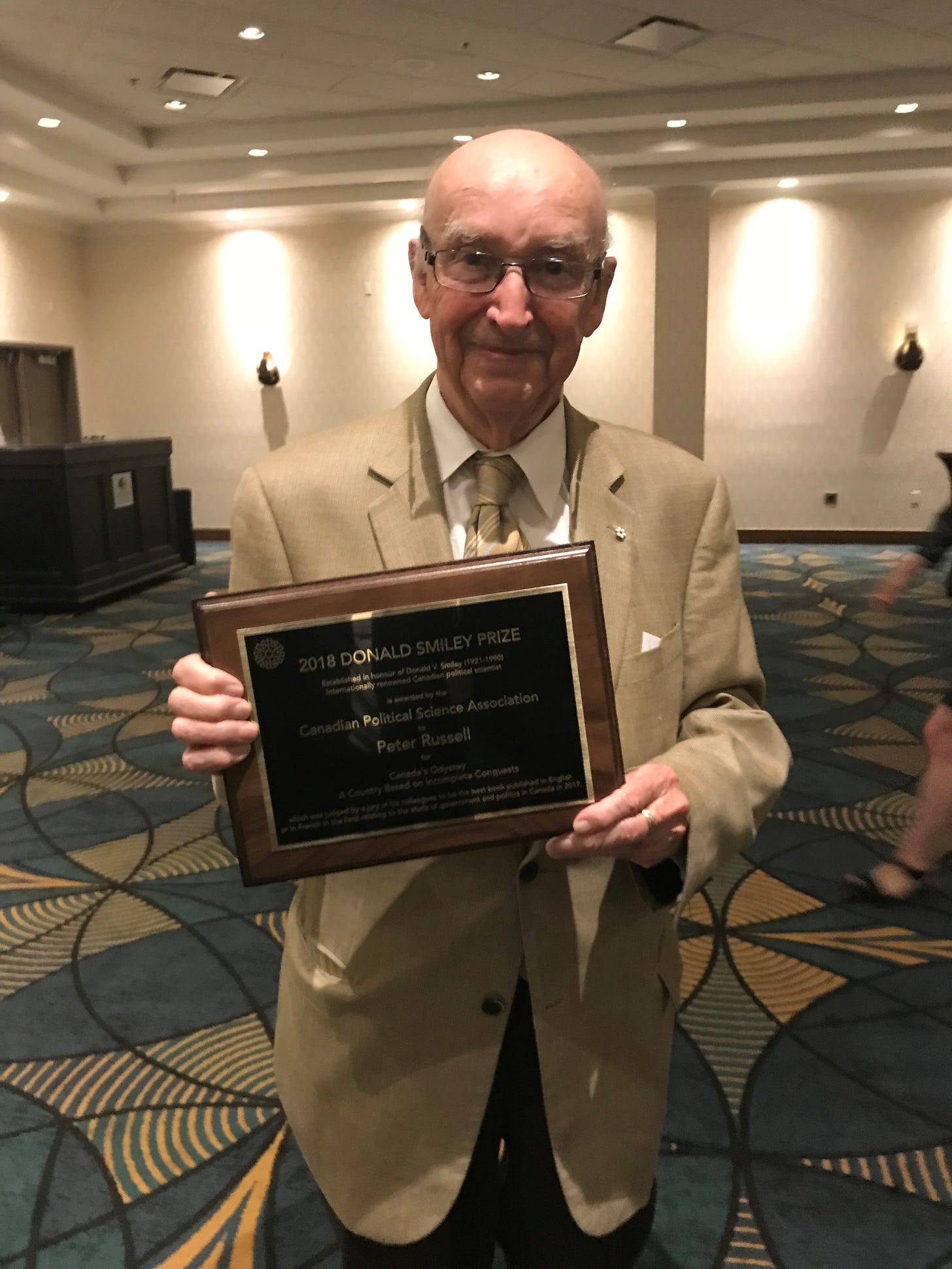 Peter Russell holding his 2018 book award.