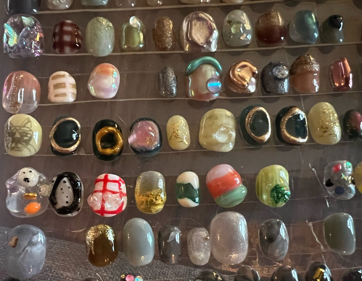 Rows of resin press on nails featuring many colors and three dimensional shapes