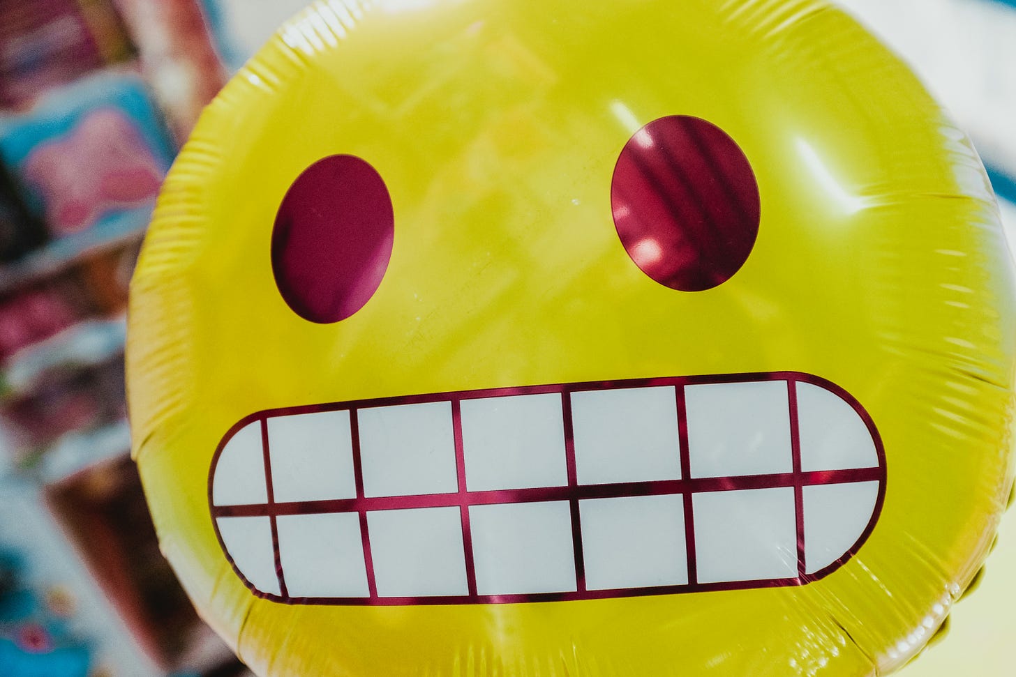 a large inflatable emoji with a grimacing expression