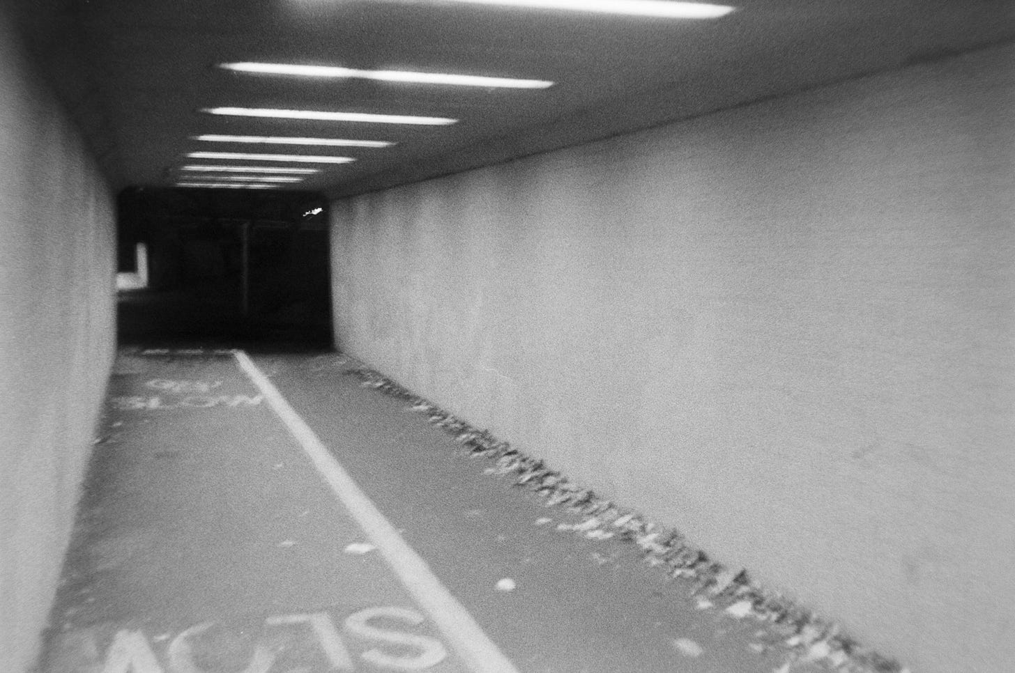 An image of an underpass, the word 'slow' mirrored on one side.