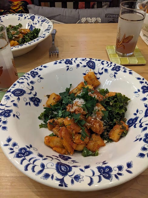 a bowl of homemade gnocchi, tomatoes, wilted kale, garlic and parsley