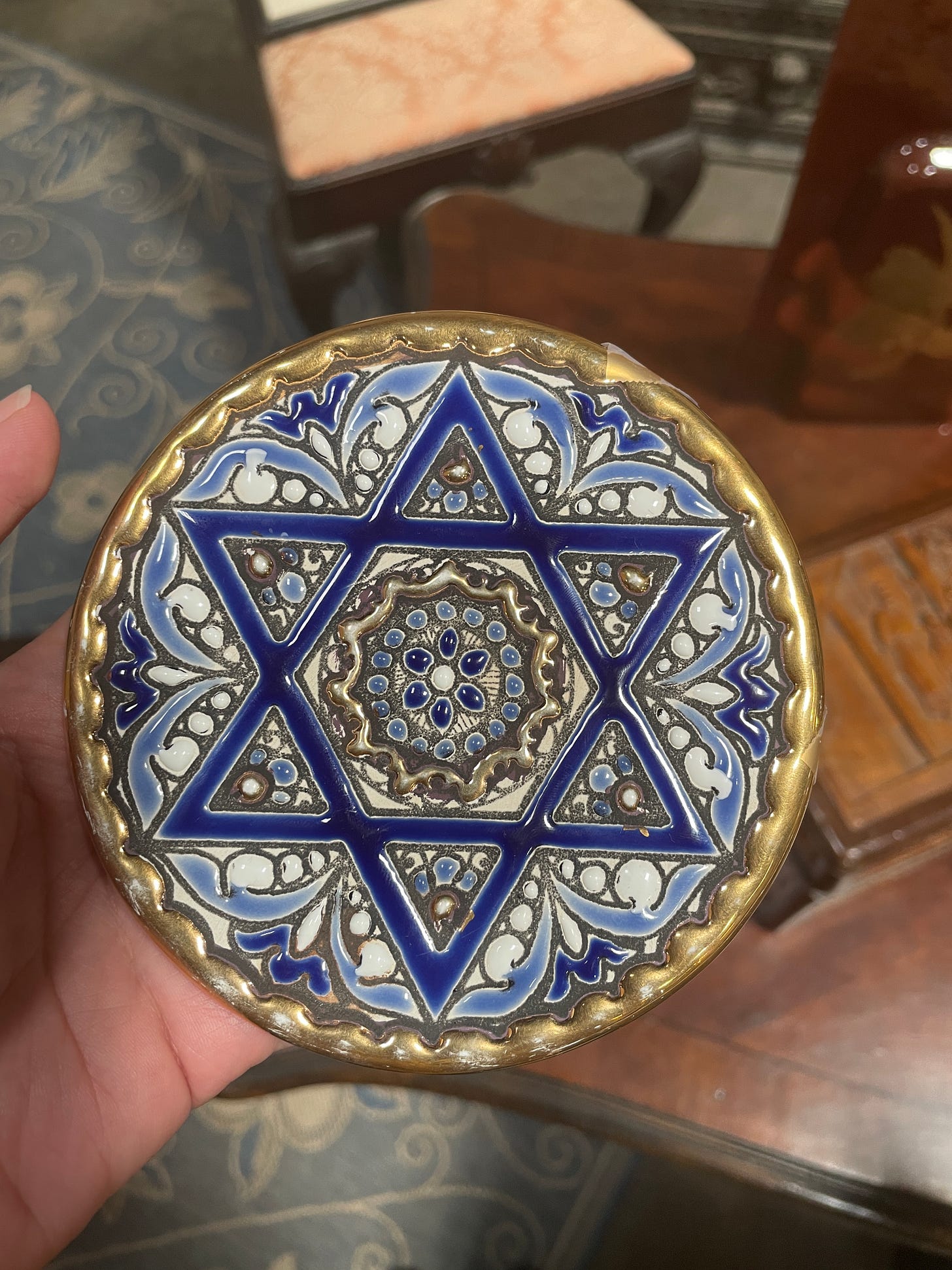 A Spanish Star of David plate. It is gold, blue, and silver.