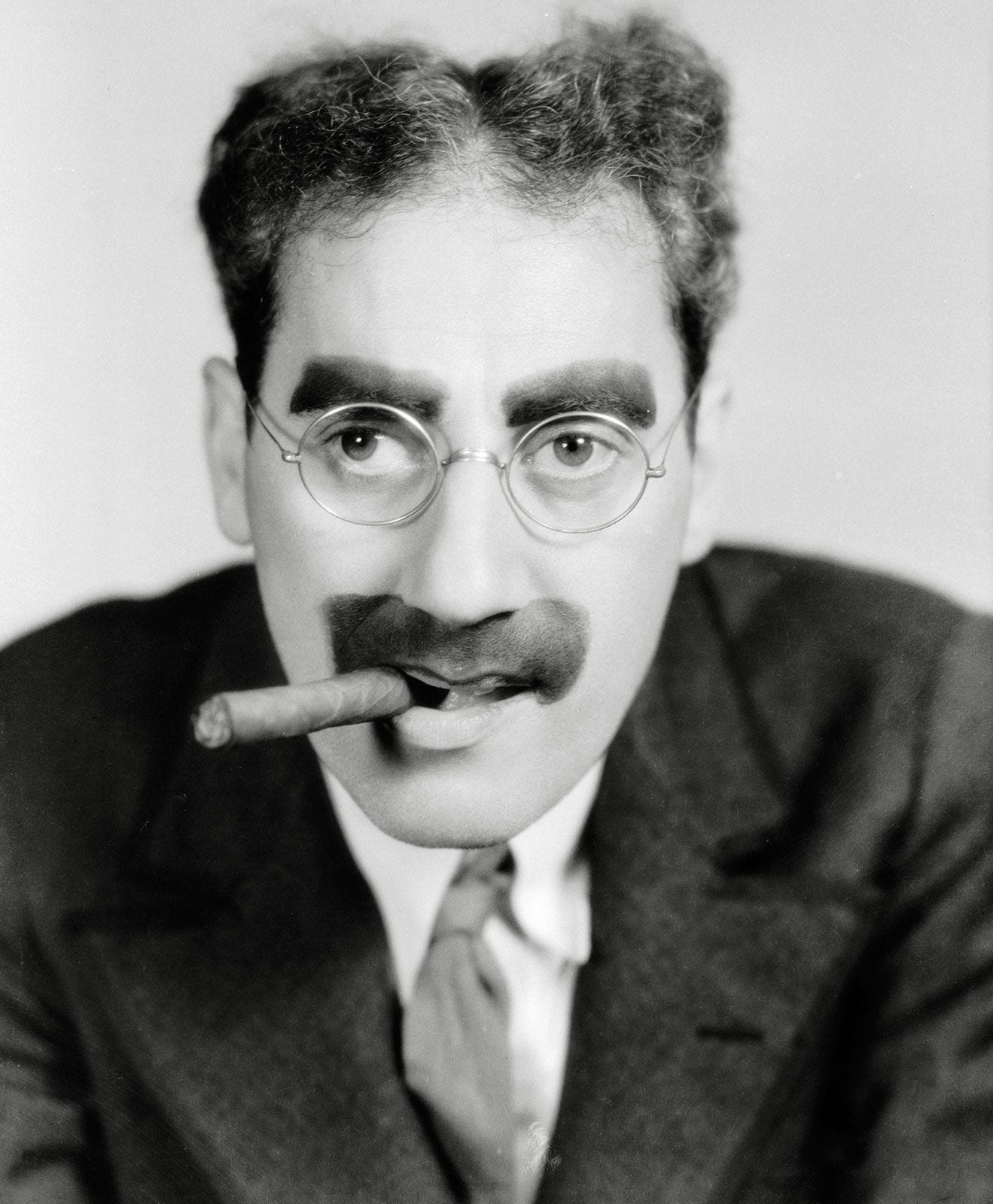 Groucho Marx with a cigar out the side of his mouth.