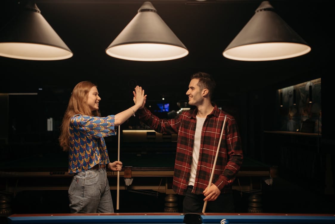 Free Man and Woman Standing Beside the Billiard Table Stock Photo