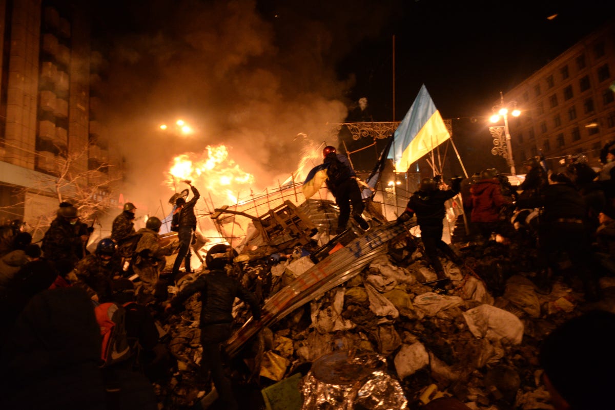 flag of Ukraine carried by a protester to the heart of developing clashes in Kyiv,