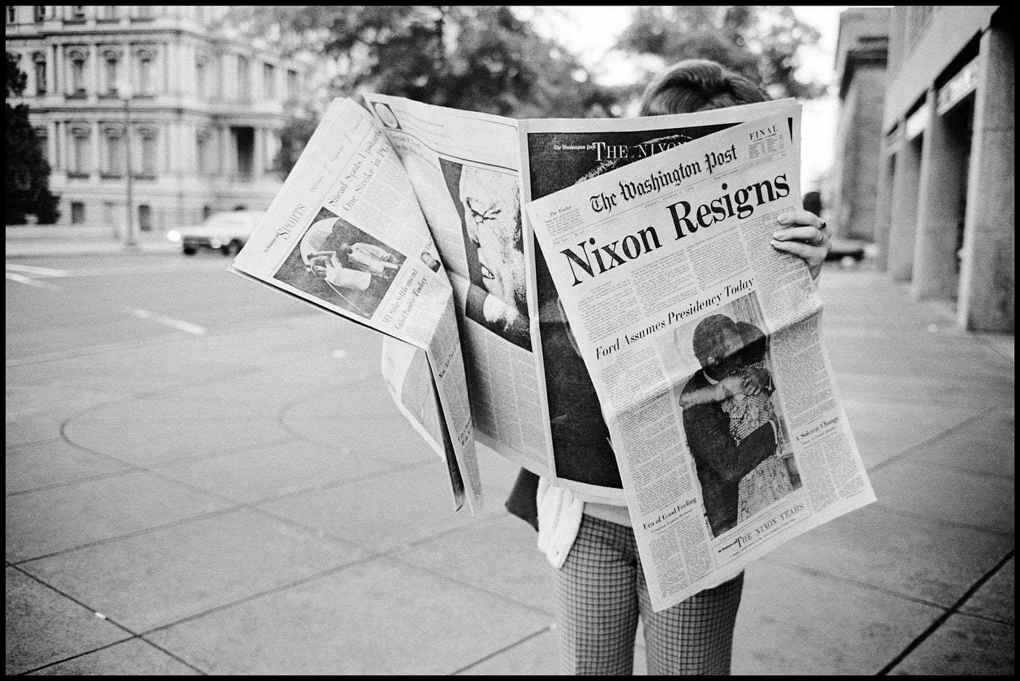 Person reads newspaper announcing Nixon's resignation