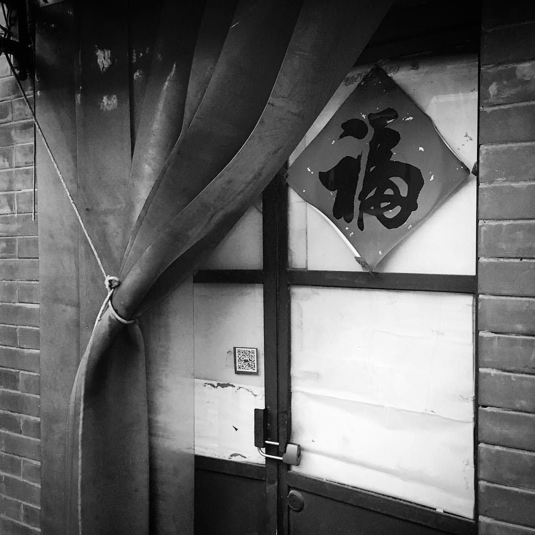 Shop in a Beijing hutong with the auspicious 福 (fú, good fortune) character pasted on the door.
