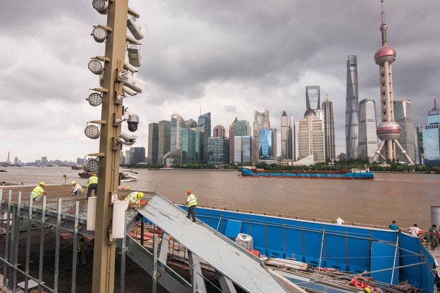 Construction workers work alongside a river in Shanghai.