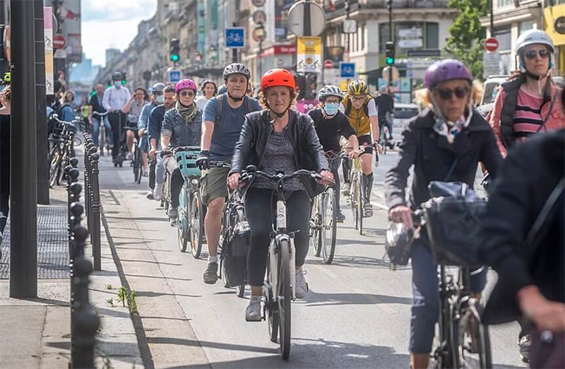 Many people biking in Paris in the streets