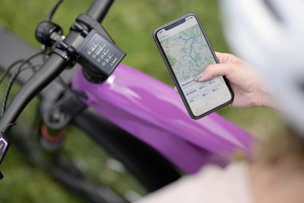 Photo showing cyclist using Bosch eBike Flow app with bike in background
