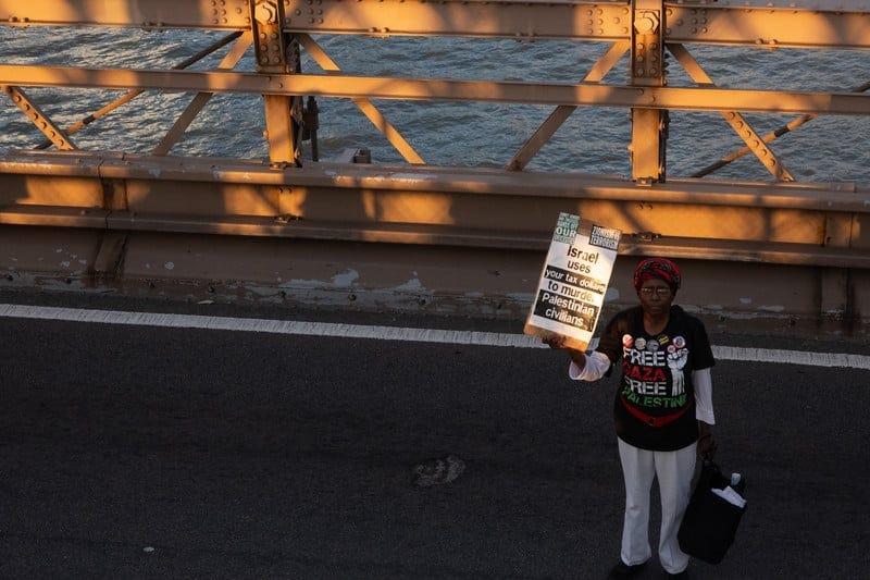 A woman stands alone with a placard A woman stands alone with a placard