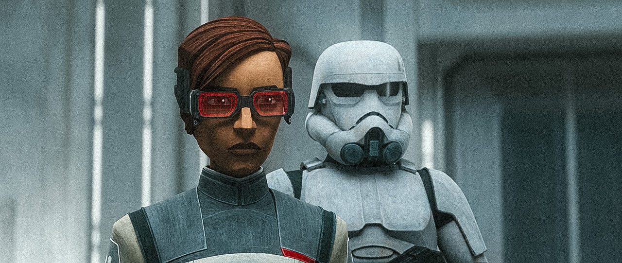 Still from The Bad Batch showing Emerie Karr, a brown-skinned woman with dark brown hair and scifi metallic glasses with red holographic lenses. She wears a grey and white medical tunic. A TK Trooper stands in pristine white armor next to her.