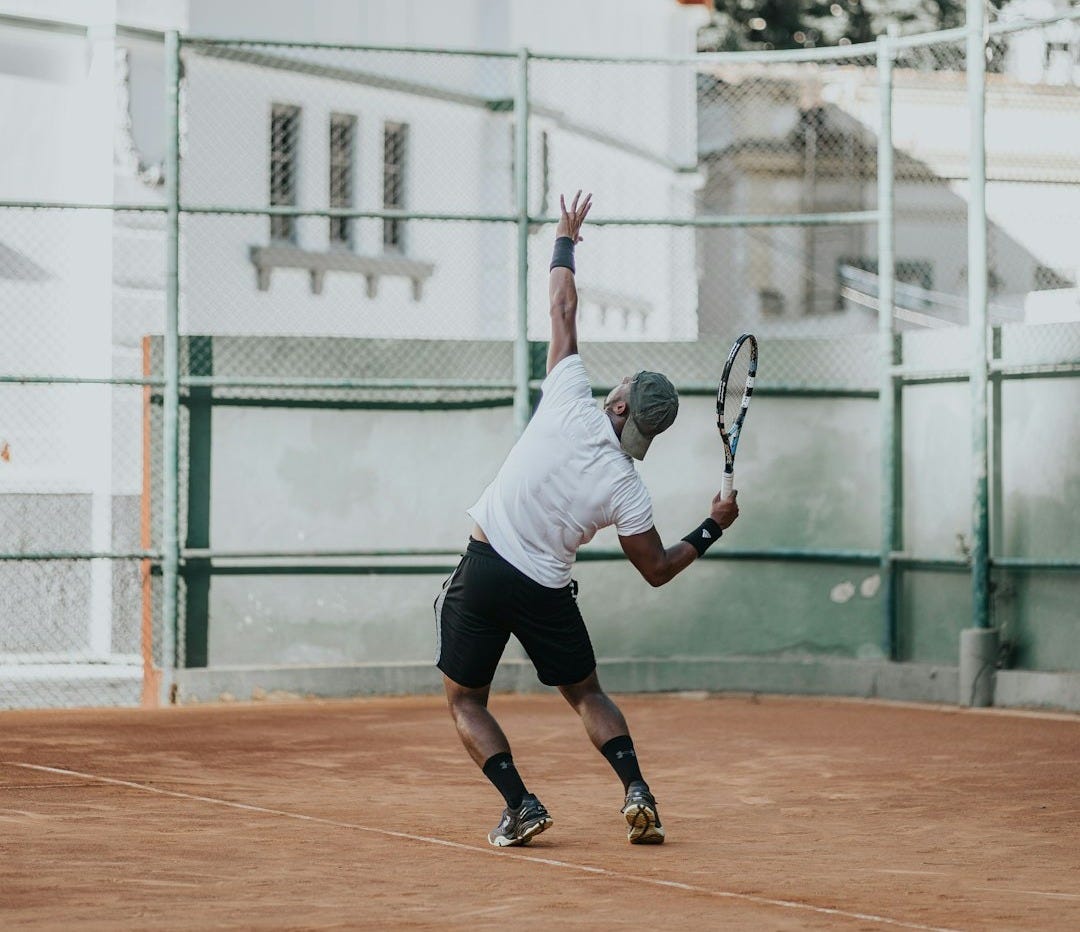 man in white t-shirt playing basketball during daytime