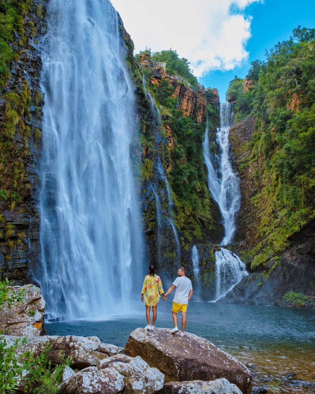 May be an image of 2 people, nature and waterfall