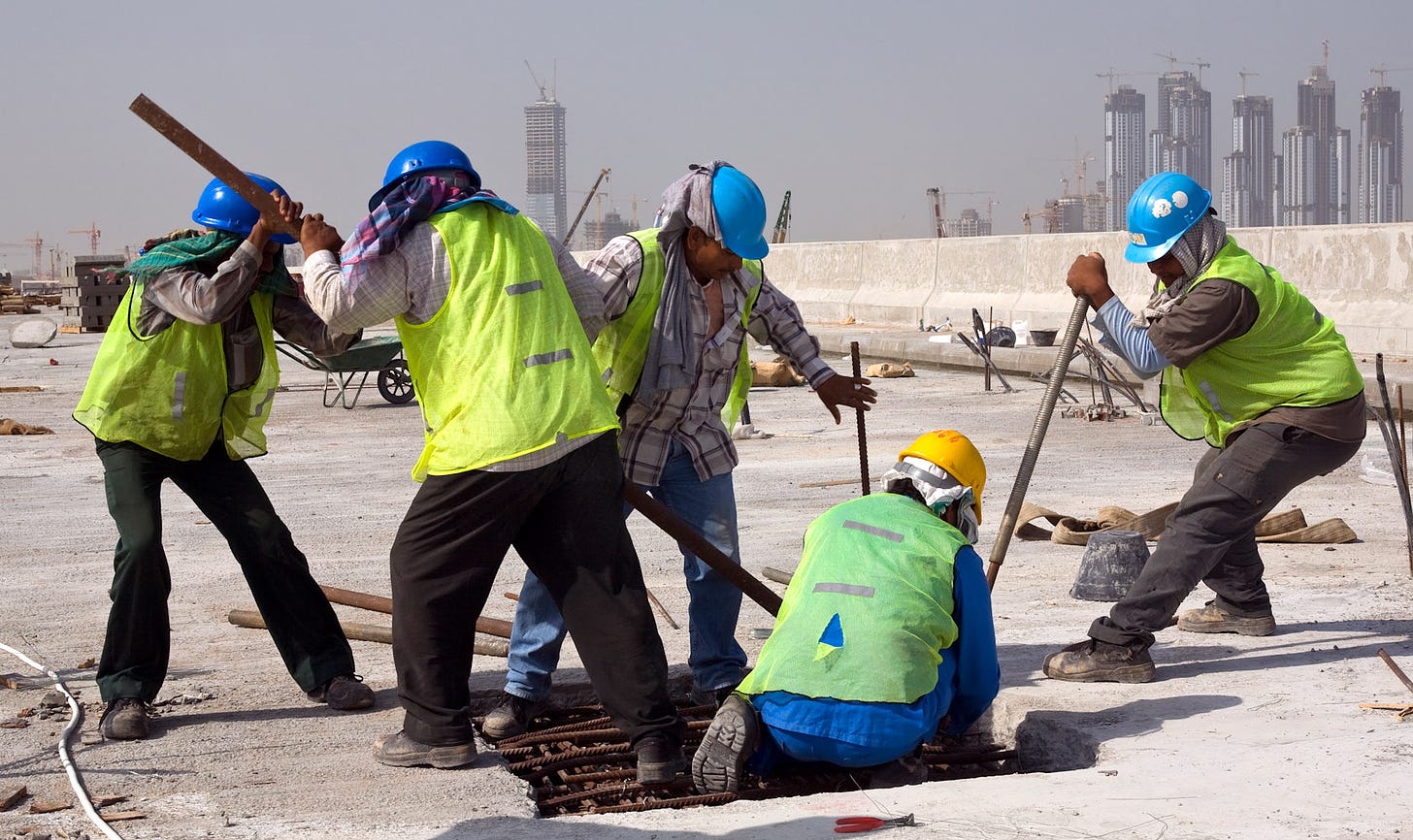 Um grupo de trabalhadores da construção civil trabalham em pleno deserto.