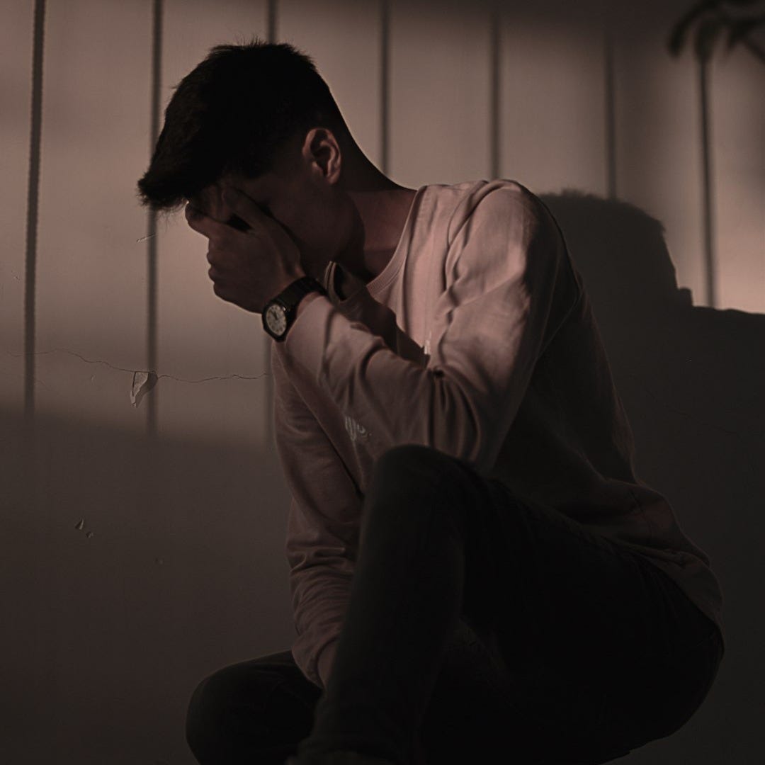 man in white dress shirt sitting on couch