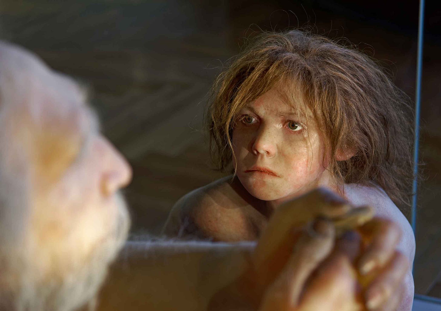 A child with vaguely Neandertal features looking up at an older man A child with vaguely Neandertal features looking up at an older man