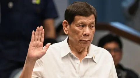 Getty Images Former Philippine president Rodrigo Duterte takes an oath as he attends a senate probe on the drug war during his administration