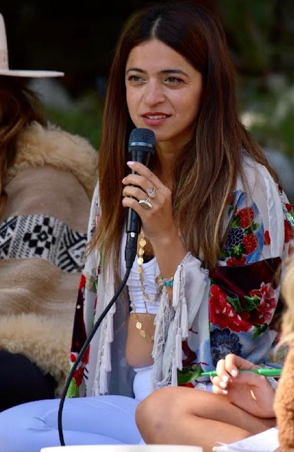 A person holding a microphone

Description automatically generated