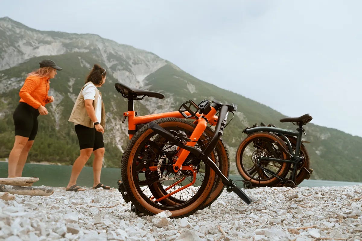 Brompton G Line folded up by mountain lake.