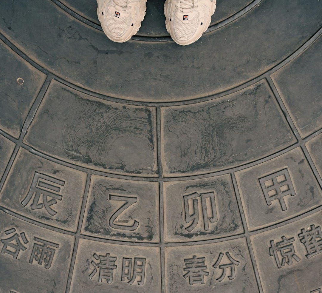 a pair of white shoes sitting on top of a cement wall