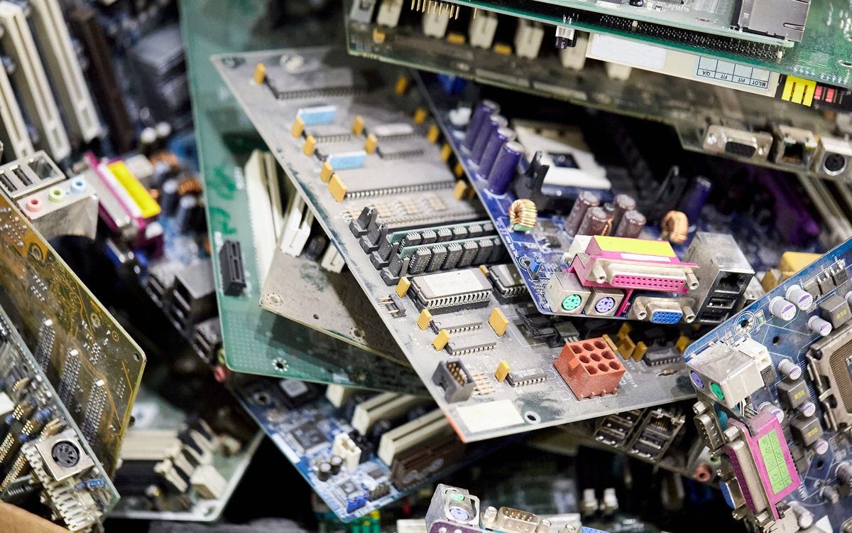 A pile of discarded computer circuit boards and electronic hardware.