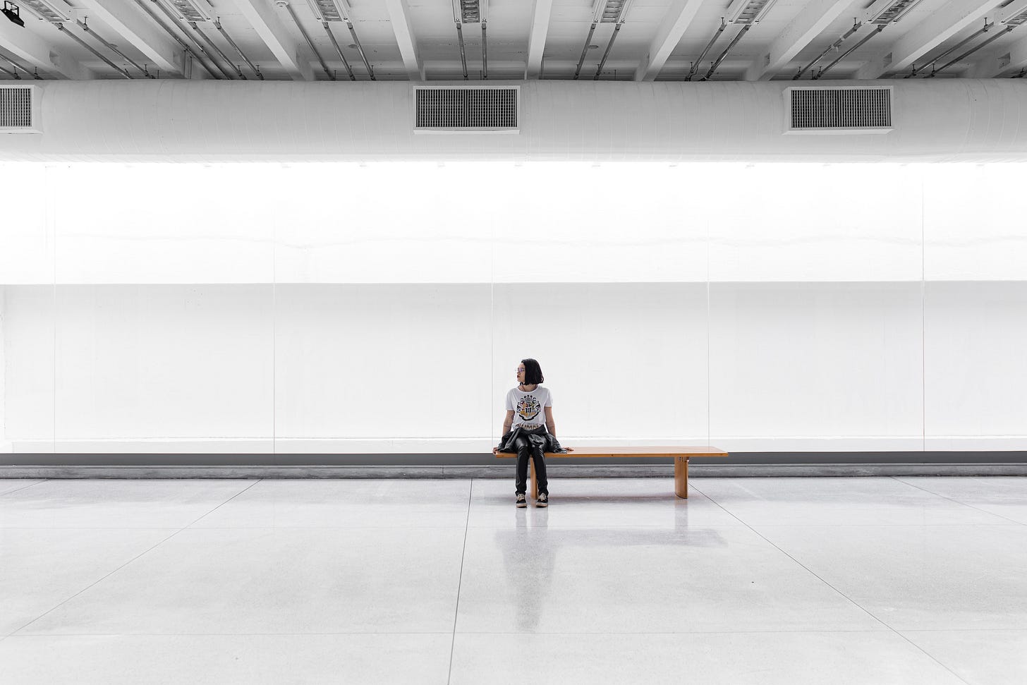 uma mulher sentada numa grande sala vazia